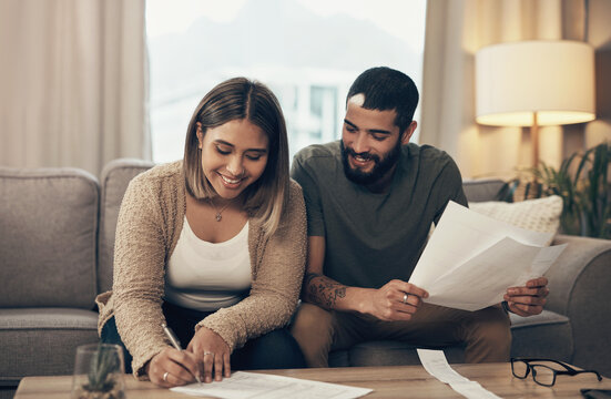 Home, couple and happy with signing documents for mortgage or loan agreement on sofa. Apartment, people and smile or satisfied with in living room with paperwork, form and contract for investment