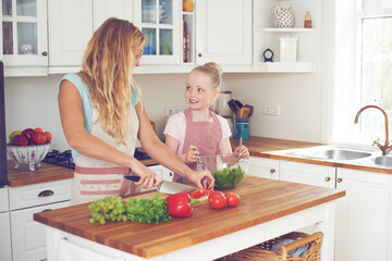Mother, child and vegetables for salad in kitchen with cutting ingredients, meal prep and teaching healthy vegan recipe. Woman, girl and learning to cook with support, helping hand or bonding in home
