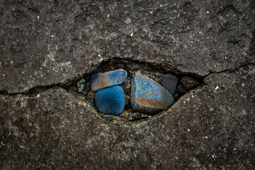Une fissure sur un quai en béton avec des galets de bretagne dedans