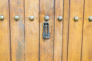 Close up of old Key in wooden door at home, Brown Wood Front Door with Ornate Brass Skeleton...