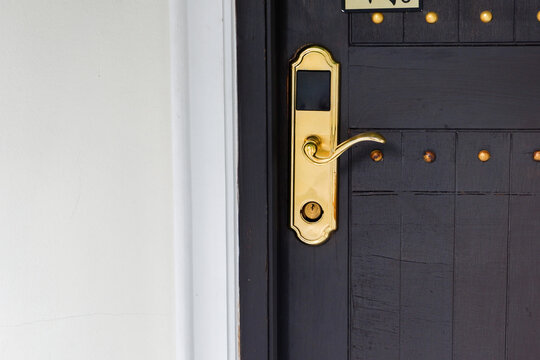 Close-up of wooden door with classic golden handles and ornaments,gold door handle and lock,Beautiful entrance to an expensive home or Luxury hotel,Copy space.