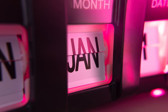 January 1st on flip calendar clock in pink light - Powered by Adobe