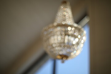 Texture, pattern, background. light crystal chandelier with blurred focus. Glamour background with copy space.