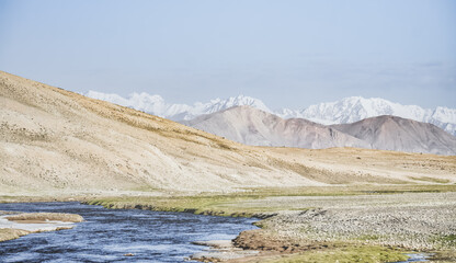 High mountain landscape panorama, a river in the mountains flows in a mountain valley among green...
