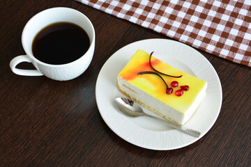 a slice of citrus cheesecake and a cup of coffee on a table 