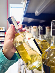 Bottle of alcohol in hand in store