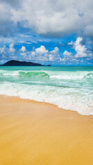 Bright yellow sunny sandy beach at tropical lagoon peaceful seaside with blue water waves and sky with white clouds as scenic tranquil tourist destination for relaxation and coastline nature enjoyment