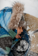 child playing with snow in winter
