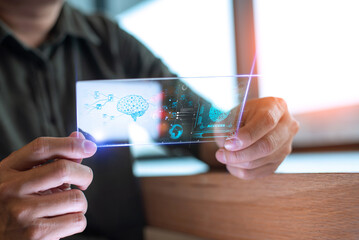 Person holding a transparent holographic screen displaying a neural network and biometric data in a futuristic technology setting.