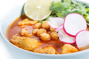 Traditional mexican red pozole soup isolated on white background. Close up