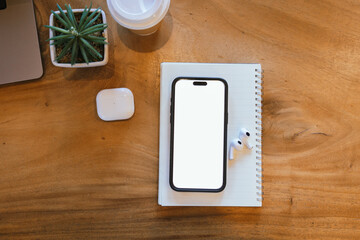 Blank laptop screen on wooden table with coffee shop interior background and blurred bokeh lights. Mockup model. Template for your text.