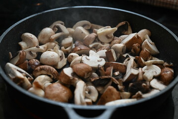 Close up view of sauteed slices of Common Mushrooms (Agaricus bisporus) cooking in the pan