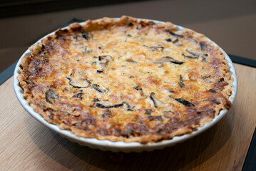 Mushrooms quiche, a French style tart consisting of pastry crust filled with savory custard and pieces of cheese and Champignon mushrooms, side view