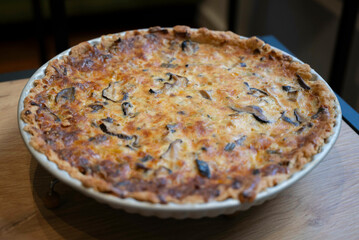 Mushrooms quiche, a French style tart consisting of pastry crust filled with savory custard and pieces of cheese and Champignon mushrooms, side view