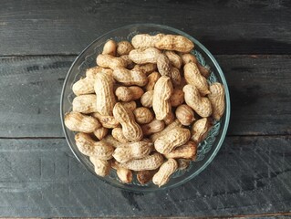 Boiled peanuts in bowl on the wooden table with flat lay angle view setup 
