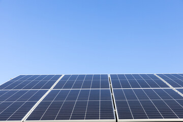 Obraz premium Aerial view of solar panel cells on clear blue sky background. Alternative energy concept. Modern house with solar panels stand-alone photovoltaic plant system on household metal sheet roof
