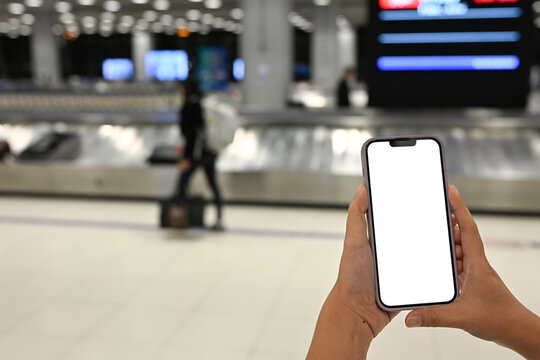 Close up of woman checking flight or baggage status on smartphone at the airport