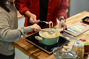 Young married couple making pasta together during the festive season