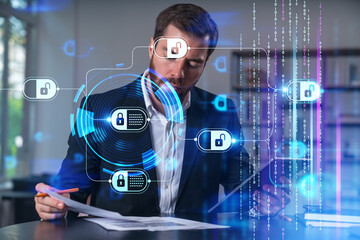Businessman analyzing documents with digital security icons overlay.
