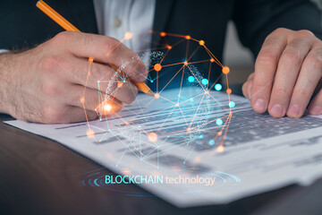 Person signing document with blockchain digital network overlay on a modern tech background.