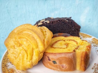 many cakes in one plate such as bronis chocolate cake, sus cake and rolled pineapple flavored cake