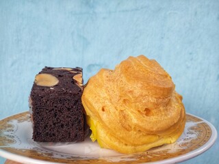 many cakes in one plate such as bronis chocolate cake, sus cake and rolled pineapple flavored cake