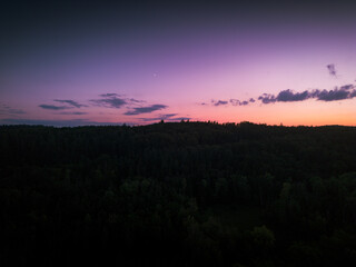 A stunning dusk view over a calm body of water, with a vibrant pink and purple gradient sky reflecting on the surface and city lights in the distance.
