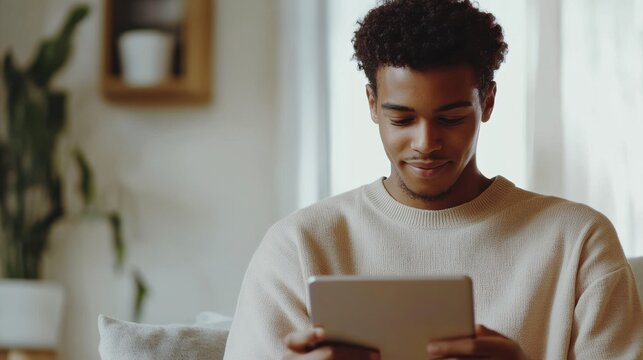 Student typing on tablet during webinar young African American man with short curly hair bright room clean background  copy space - Powered by Adobe