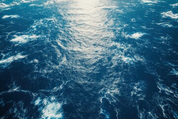 Fototapeta premium Captivating view of deep blue ocean waves under bright sunlight reflecting off the surface