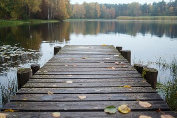 Obraz premium A serene wooden pier surrounded by autumn foliage at a peaceful lakeside in the afternoon