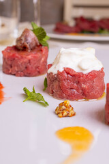 Tartare di manzo guarnite con burrata pugliese, acciughe e capperi servite come antipasto in un ristorante elegante