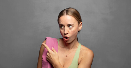 feeling joyful and surprised, smiling with a shocked expression and pointing to the side