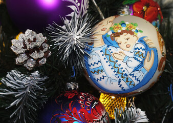 Ukrainian Christmas ball with a picture of a mother hugging a child hanging on a Christmas tree