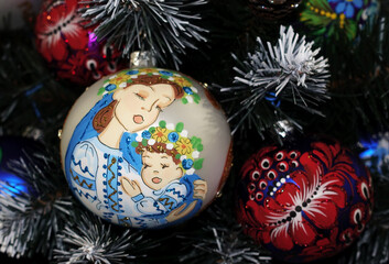 Ukrainian Christmas ball with a picture of a mother hugging a child hanging on a Christmas tree