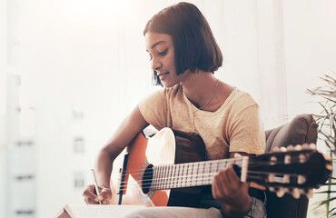 Girl, guitar and writing music in home for audio production, song composition and practice for performance. Musician, artist and planning notes for track recording, creative lyrics or record producer