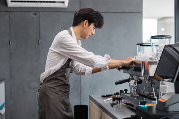 Fototapeta premium Young Entrepreneur Brewing Coffee in Modern Cafe Startup Environment with Professional Equipment