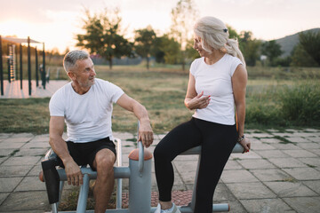 Amputee athlete resting together with supportive friend in the outdoor gym