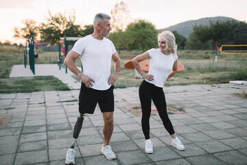 Active amputee athlete exercising with his female friend in the outdoor gym