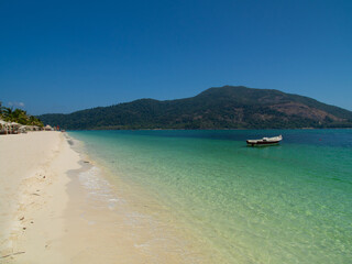 Pristine Beach with Clear Turquoise Waters and Boat on Koh Lipe, Thailand