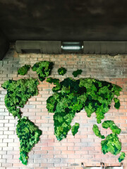 Green moss world map on brick wall with industrial design