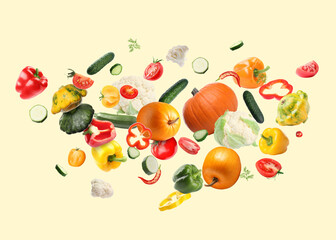 Many different fresh vegetables in air on beige background