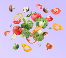 Many different fresh vegetables in air on violet background