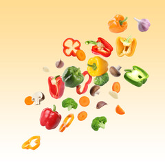 Many different fresh vegetables in air on light orange gradient background
