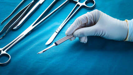 Close-up of a surgeon holding a scalpel in an operating room.