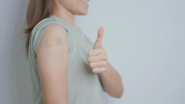 Woman with bandage after receiving vaccine. Vaccination and Immunization for Influenza, HPV, Zoster, IPD, DTP or Diphtheria, Tetanus and Pertussis, MMR, Hepatitis B, Covid  and Varicella vaccine