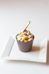 A glass made from chocolate milk with a chocolate spoon and marsmellows on white plate isolated on white background, concept for menus or recipe 
