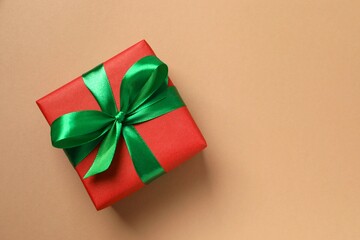 Beautiful gift box tied with golden bow on color background 