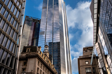 The image showcases a city scene where tall, reflective skyscrapers tower above a historic building, highlighting the intersection of modern innovation and classic architecture in London UK