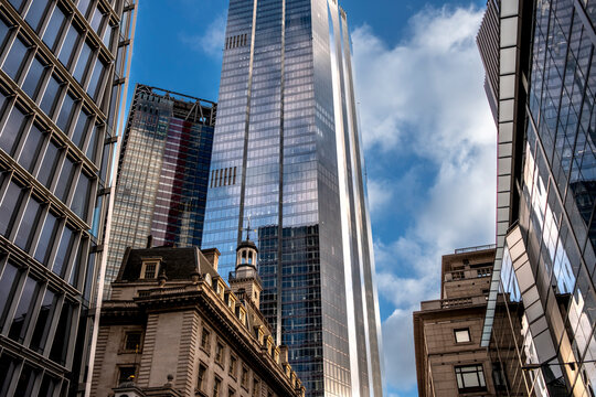 The image showcases a city scene where tall, reflective skyscrapers tower above a historic building, highlighting the intersection of modern innovation and classic architecture  in London UK
