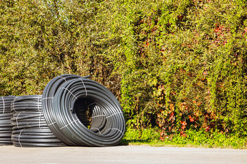 roll of black plastic pipe in the park. coiled plastic pipe. park improvement